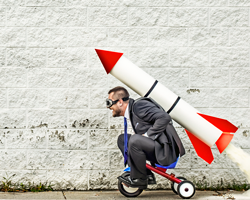 Let's get this thing moving! man on tricycle with rocket strapped to his back